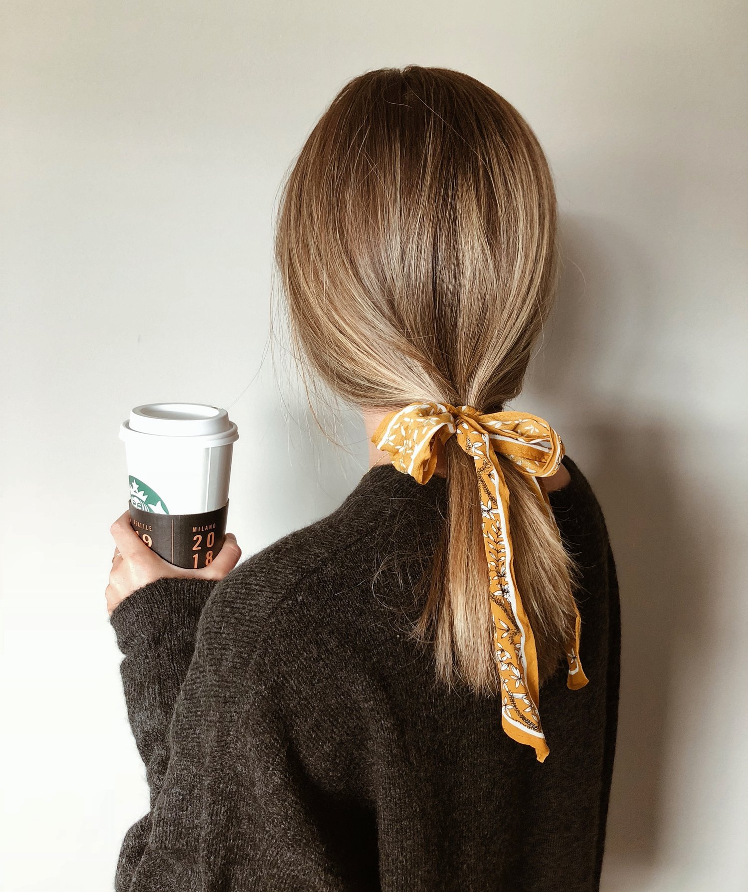 come pettinare i capelli con la mascherina: la coda bassa con il foulard è glam