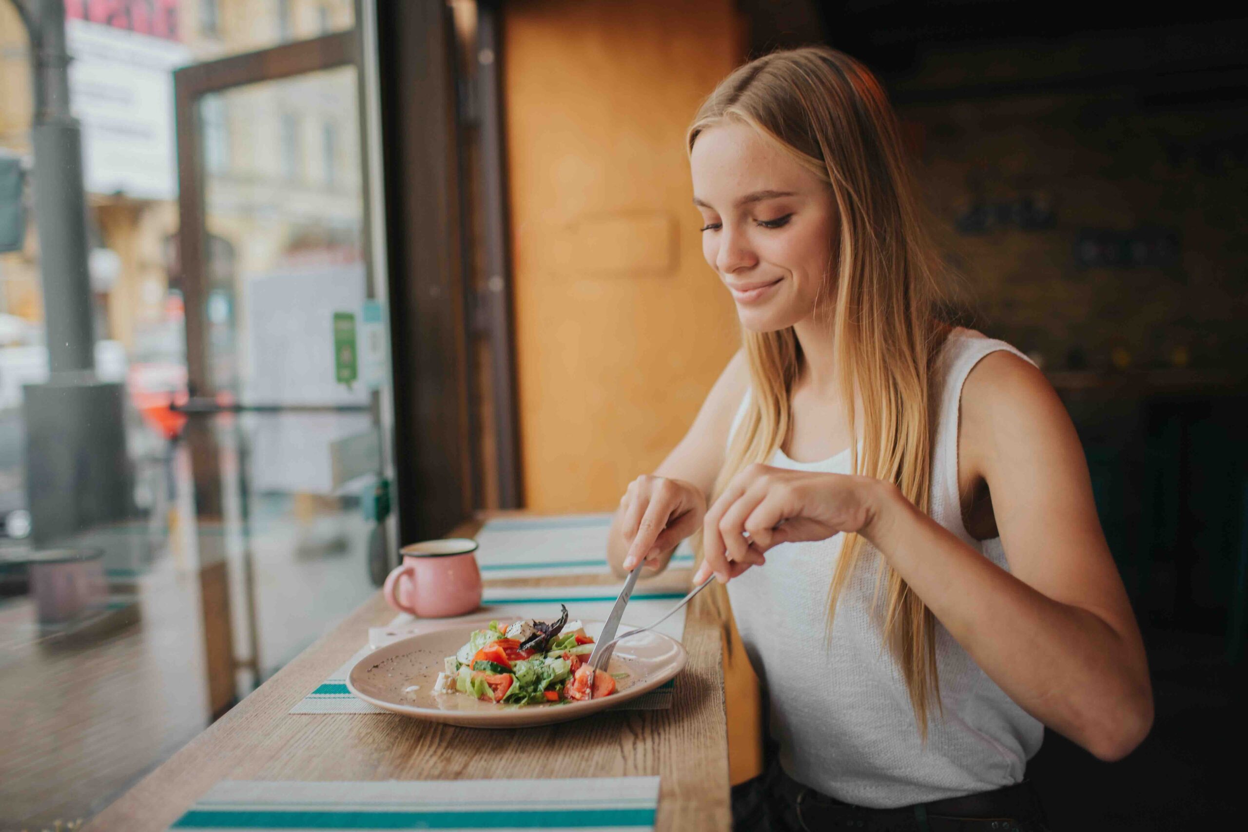 donna-mindful-eating-sorridente-mangiare-insalata